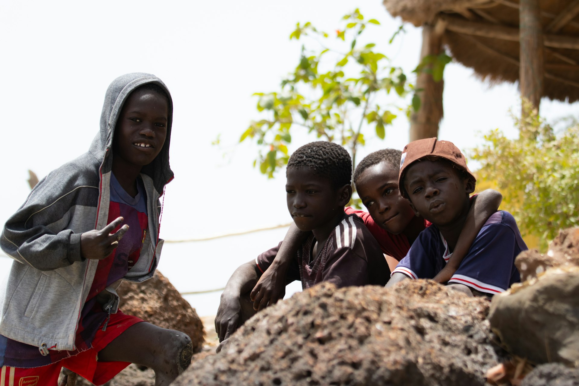 a group of children sitting on top of a pile of rocks